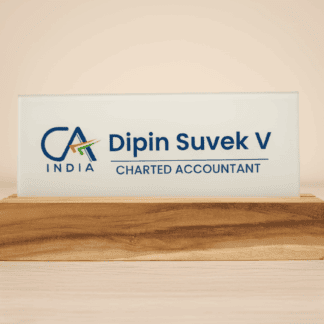 Acrylic name plate engraved with "Dipin Suvek V" and "Chartered Accountant" on a wooden stand.